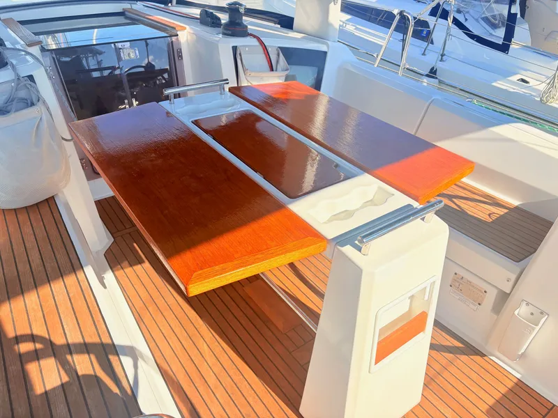 Slide: The Image of The cockpit area of a Beneteau Oceanis 35.1 with a glossy wooden table and teak flooring. - 5