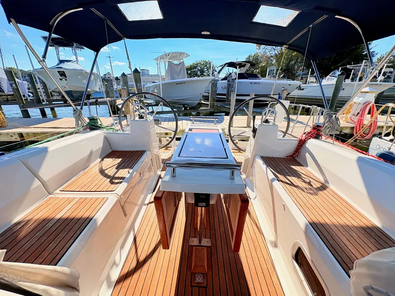 Slide: The Image of The cockpit of a Beneteau Oceanis 35.1 with wooden flooring and dual steering wheels, docked at a marina. - 40