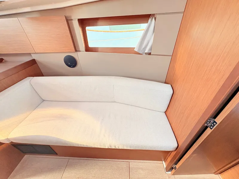 Slide: The Image of Interior of a Beneteau Oceanis 35.1 featuring a beige sofa and wood paneling. - 31