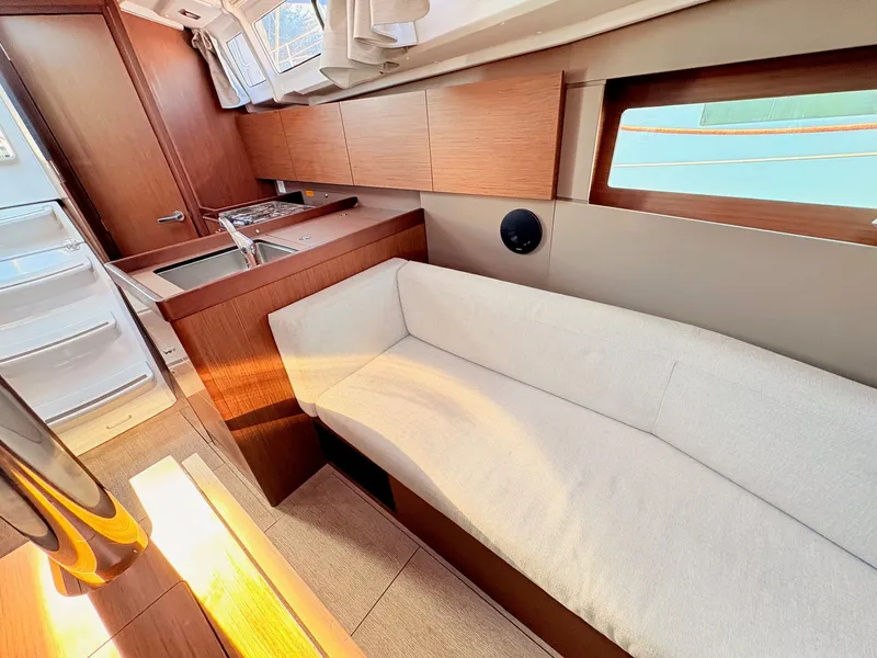 Slide: The Image of Interior of a 2020 Beneteau Oceanis 35.1 with light upholstery and wooden cabinetry. - 32