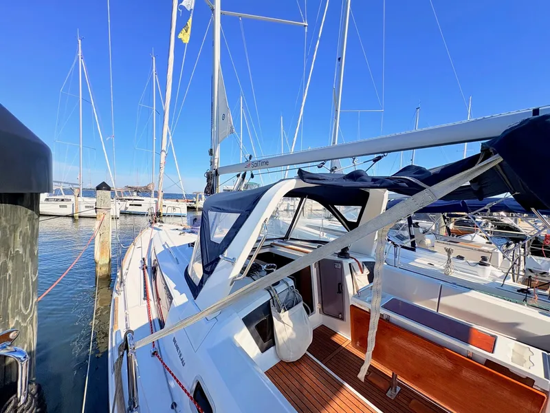 Slide: The Image of A 2020 Beneteau Oceanis 35.1 docked at a marina. It features sleek design and a spacious cockpit. - 43