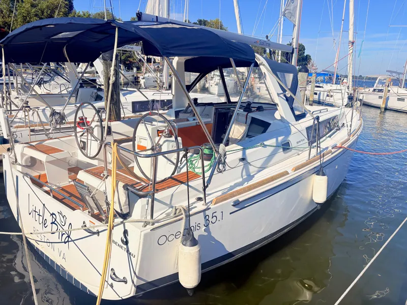 The Image of A 2020 Beneteau Oceanis 35.1 is docked. It features a blue sunshade and dual steering wheels. - 2