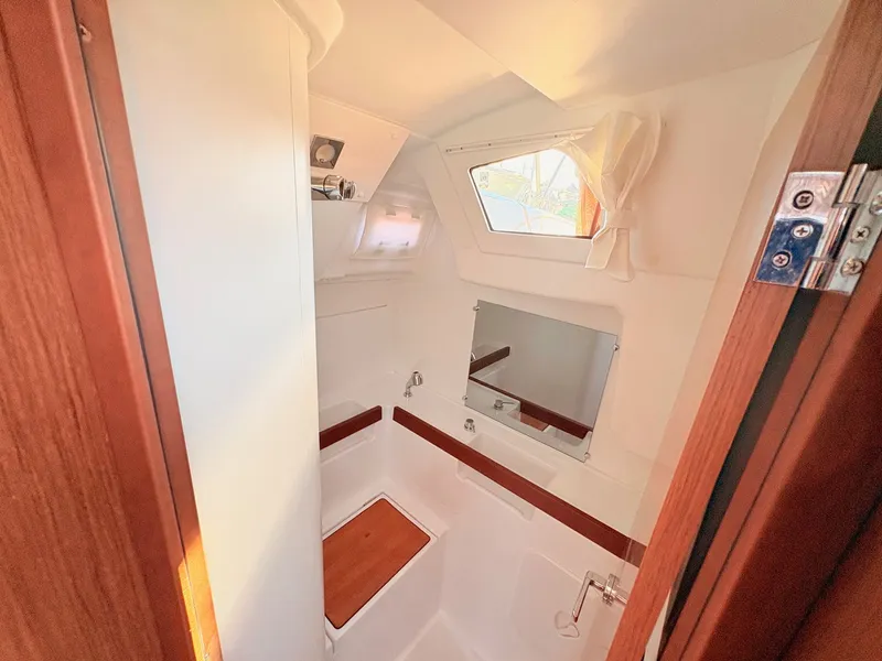 Slide: The Image of The image shows the bathroom of a 2020 Beneteau Oceanis 35.1 with wooden accents. - 18