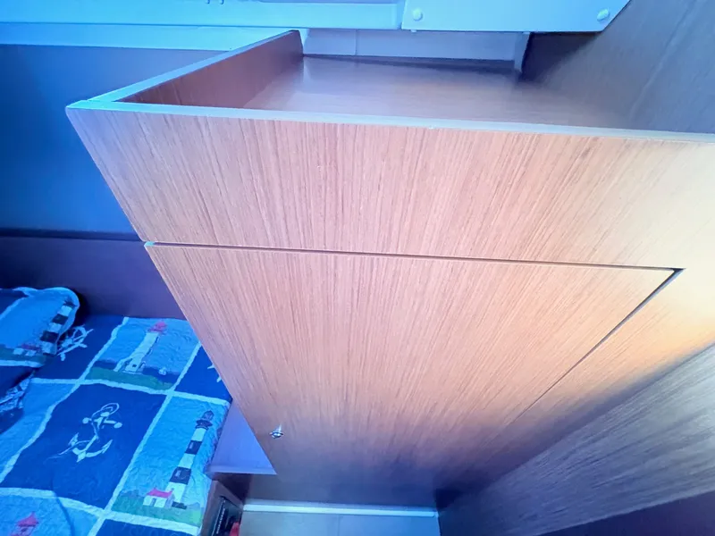 Slide: The Image of Interior of a Beneteau Oceanis 35.1 with wooden furniture and a bed with nautical-themed bedding. - 37