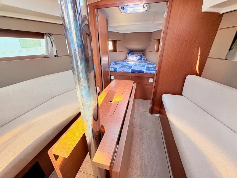 Slide: The Image of Interior view of a 2020 Beneteau Oceanis 35.1 with cozy seating areas and a bed in the background. - 24