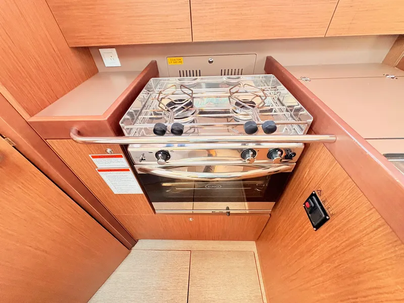 Slide: The Image of The galley of the 2020 Beneteau Oceanis 35.1 features a modern stove with two burners. - 34