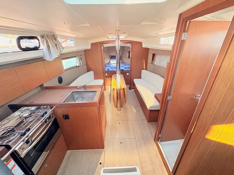 Slide: The Image of Interior of a 2020 Beneteau Oceanis 35.1 featuring a kitchen, seating area, and sleeping cabin. - 17