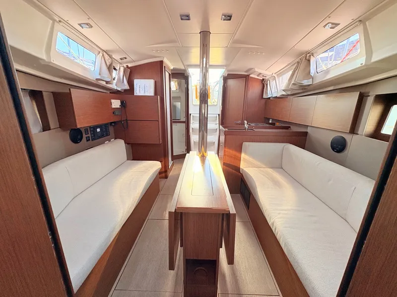 Slide: The Image of Interior of a 2020 Beneteau Oceanis 35.1 with two white sofas and wooden furnishings. - 30