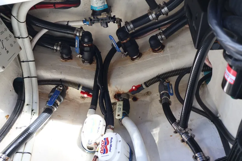 Slide: The Image of Engine compartment of a 2017 Yellowfin 42 Offshore boat, showcasing hoses and valves. - 30