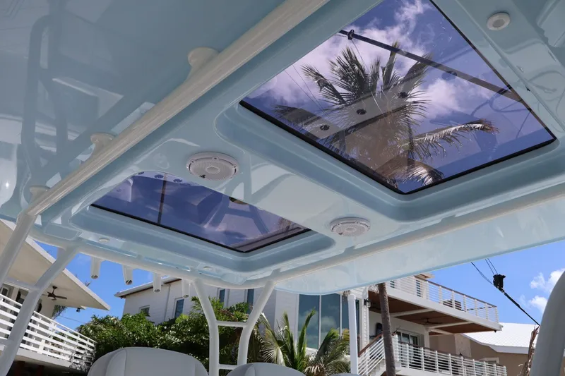 Slide: The Image of 2017 Yellowfin 42 Offshore boat roof with skylights, palm tree reflection, and clear blue sky. - 11