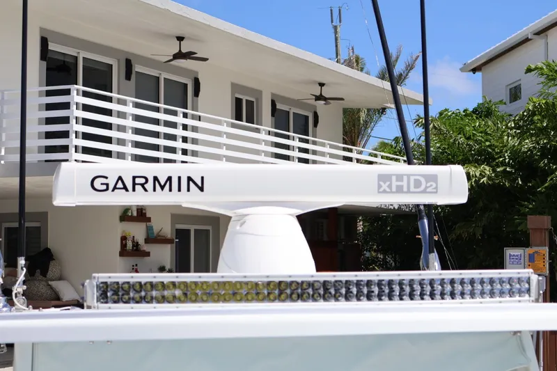 Slide: The Image of 2017 Yellowfin 42 Offshore boat with Garmin xHD2 radar, docked near a modern house. - 22