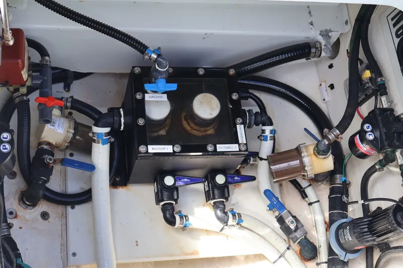 Slide: The Image of Engine compartment of a 2017 Yellowfin 42 Offshore boat, showcasing intricate plumbing and wiring. - 29