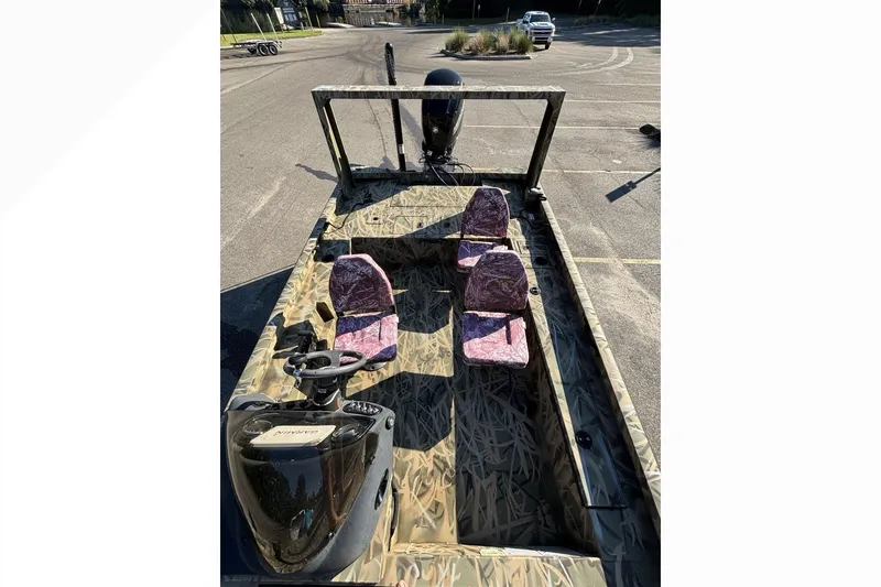 Slide: The Image of 2025 Lowe Outlet 20 boat with camouflage design and four seats in a parking lot. - 15