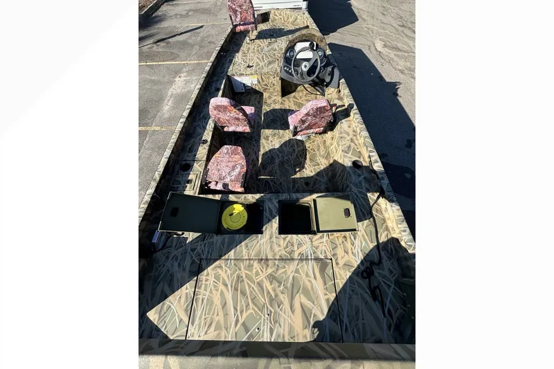 Slide: The Image of Camouflage-patterned Lowe Outlet 20 boat interior with steering wheel and seating, 2025 model. - 11