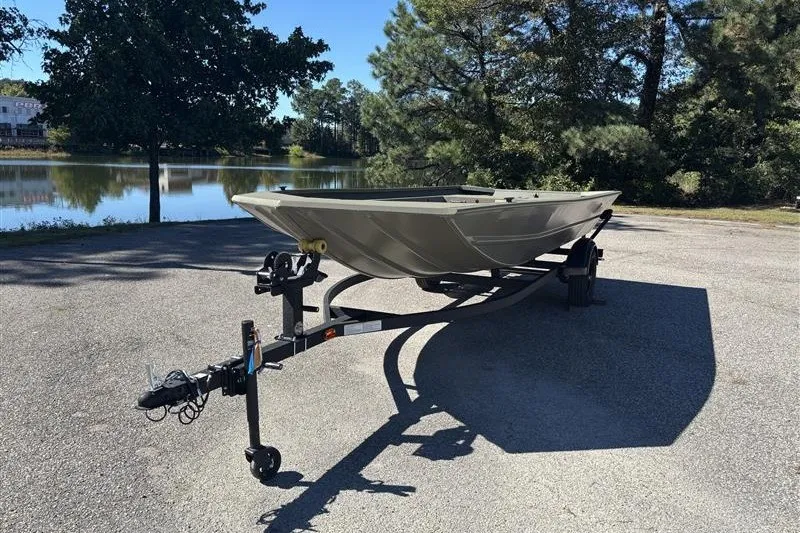 The Image of 2027 Tracker Grizzly 1754 Utility boat on trailer by a scenic lake. - 0
