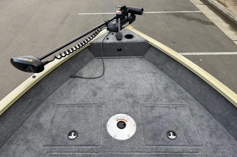 Slide: The Image of 2027 Tracker Pro Guide V-16 WT boat deck with trolling motor, parked on asphalt. - 13