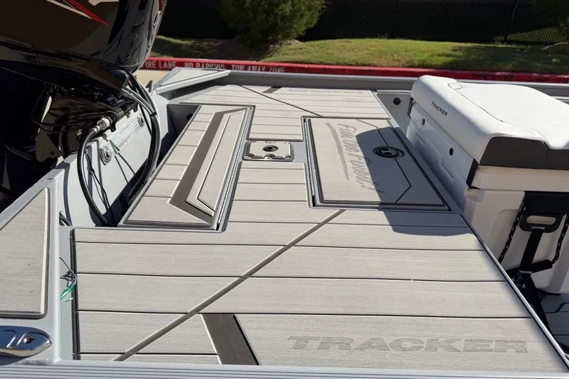 Slide: The Image of 2027 Tracker Bass Tracker Classic CC boat deck with seating and motor, in sunlight. - 15