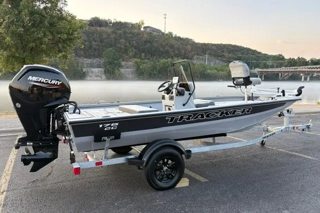 Slide: The Image of 2027 Tracker Bass Tracker 175 CC boat with Mercury engine, parked by a scenic riverside. - 14