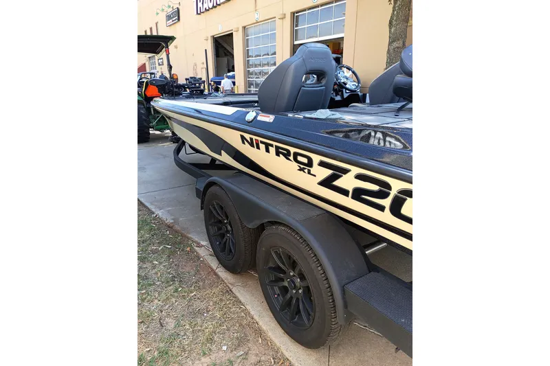 Slide: The Image of 2027 Nitro Z20 XL Pro boat parked outside a building, showcasing sleek design and black wheels. - 1