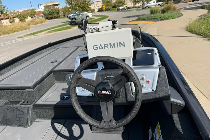 Slide: The Image of Steering wheel and Garmin display on 2027 Tracker Savage 215 boat dashboard. - 18