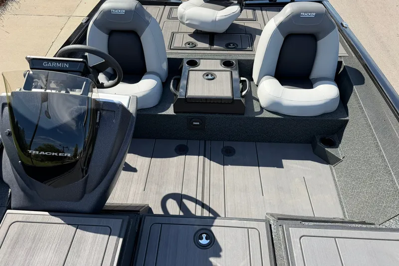 Slide: The Image of 2027 Tracker Savage 215 boat interior with Garmin dashboard and cushioned seats. - 24