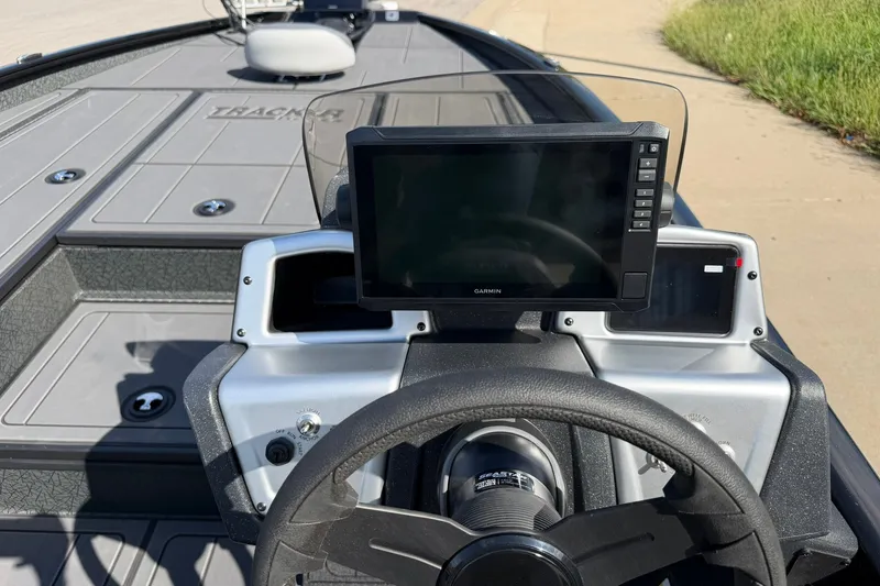 Slide: The Image of 2027 Tracker Savage 215 boat dashboard with Garmin display and steering wheel. - 17
