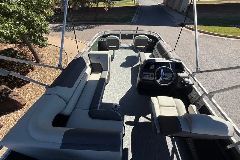 Slide: The Image of 2027 Sun Tracker Fishin' Barge 22 DLX interior with spacious seating and steering console. - 13
