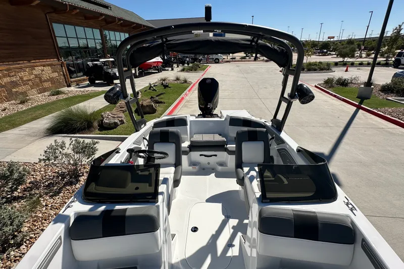 Slide: The Image of 2027 Tahoe T21 boat interior with seating and dashboard, parked outdoors. - 15