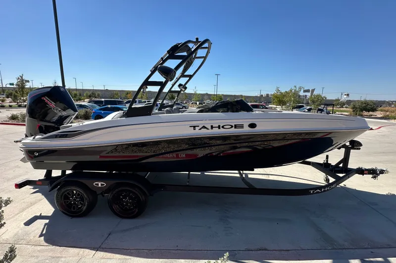 Slide: The Image of 2027 Tahoe T21 boat on trailer, parked outdoors under clear blue sky. - 6