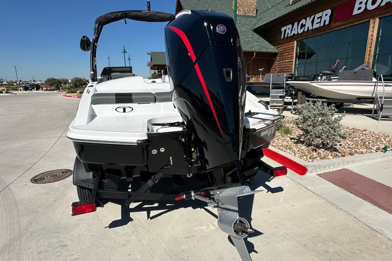 Slide: The Image of 2027 Tahoe T21 boat with outboard motor, parked outside Tracker Boats dealership. - 7