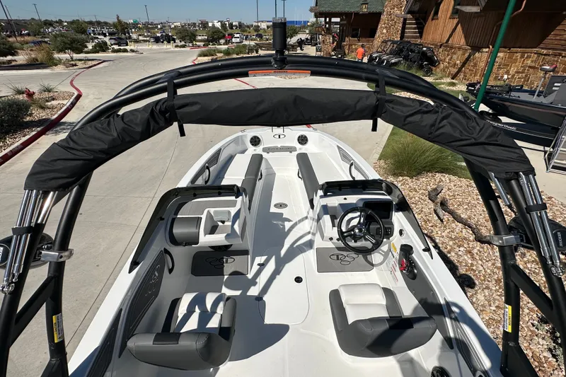Slide: The Image of 2027 Tahoe T21 boat interior with steering wheel and seating, parked outdoors. - 17