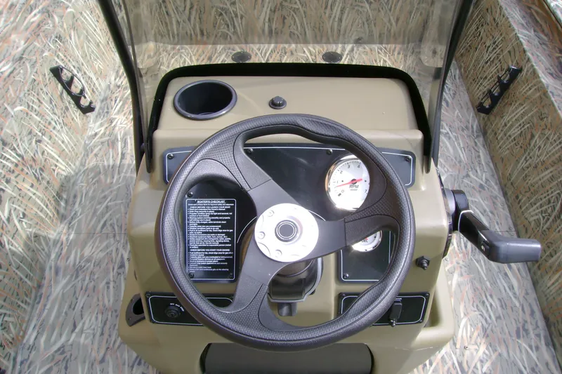 Slide: The Image of Steering console of 2027 Tracker Grizzly 1860 CC boat with camo design and gauges. - 13