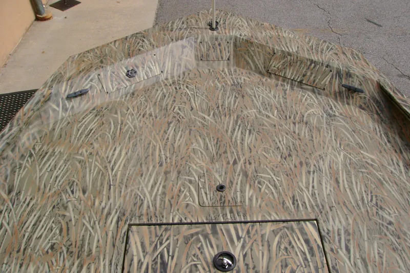 Slide: The Image of Camo-patterned deck of 2027 Tracker Grizzly 1860 CC boat, featuring storage compartments. - 15
