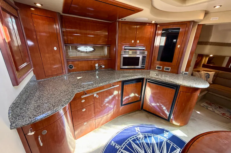 Slide: The Image of Luxurious 2005 Sea Ray 420 Sundancer yacht interior with elegant wood cabinetry and modern appliances. - 20