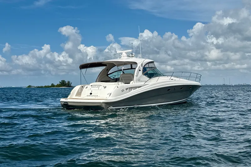 Slide: The Image of 2005 Sea Ray 420 Sundancer yacht cruising on open water under a cloudy sky. - 33