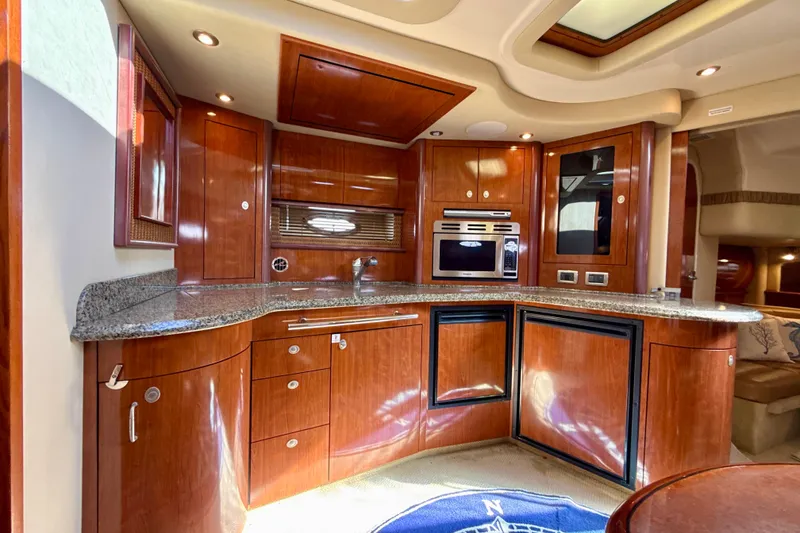 Slide: The Image of Luxurious 2005 Sea Ray 420 Sundancer yacht kitchen with wood cabinetry and modern appliances. - 18