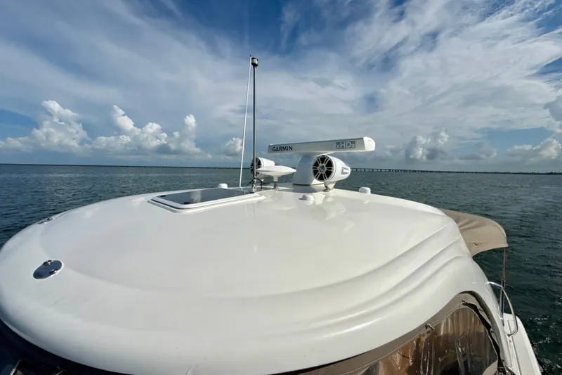 Slide: The Image of 2005 Sea Ray 420 Sundancer yacht with Garmin radar on open water under blue sky. - 27