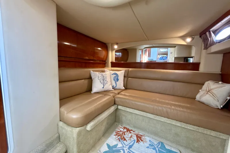 Slide: The Image of Interior of 2005 Sea Ray 420 Sundancer with beige leather seating and nautical-themed pillows. - 24