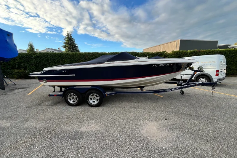 The Image of 2008 Chris-Craft Launch 22 boat on trailer, parked outdoors under a cloudy sky. - 0