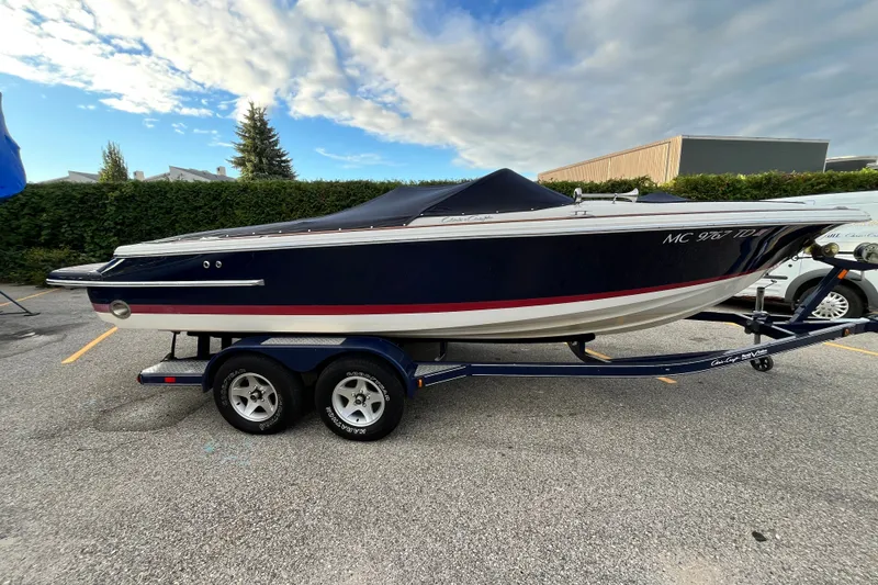 Slide: The Image of 2008 Chris-Craft Launch 22 boat on trailer, parked outdoors under cloudy sky. - 1