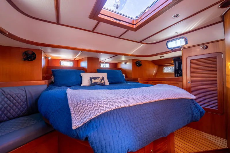 Slide: The Image of Luxurious cabin interior of a 2004 Hylas 54 yacht with blue bedding and wood finish. - 18