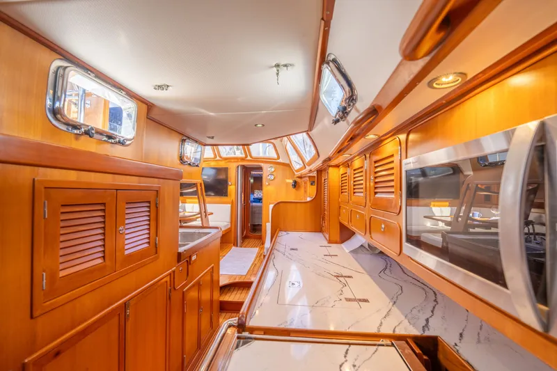 Slide: The Image of Luxurious interior of a 2004 Hylas 54 yacht with elegant wood cabinetry and modern appliances. - 17