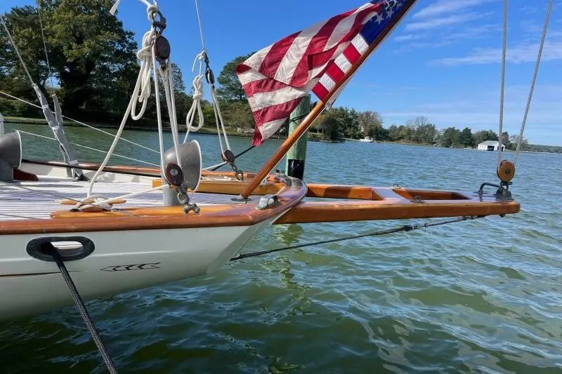 Slide: The Image of Vintage 1932 Nevins 46 Yawl sailboat with American flag on calm water. - 14