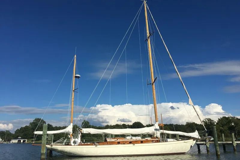 The Image of Vintage 1932 Nevins 46 Yawl sailboat docked under clear blue sky. - 1