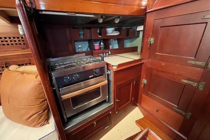 Slide: The Image of Vintage 1932 Nevins 46 Yawl galley with wooden cabinetry and stove. - 11