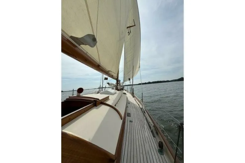 Slide: The Image of 1932 Nevins 46 Yawl sailing on calm waters under cloudy skies. - 13