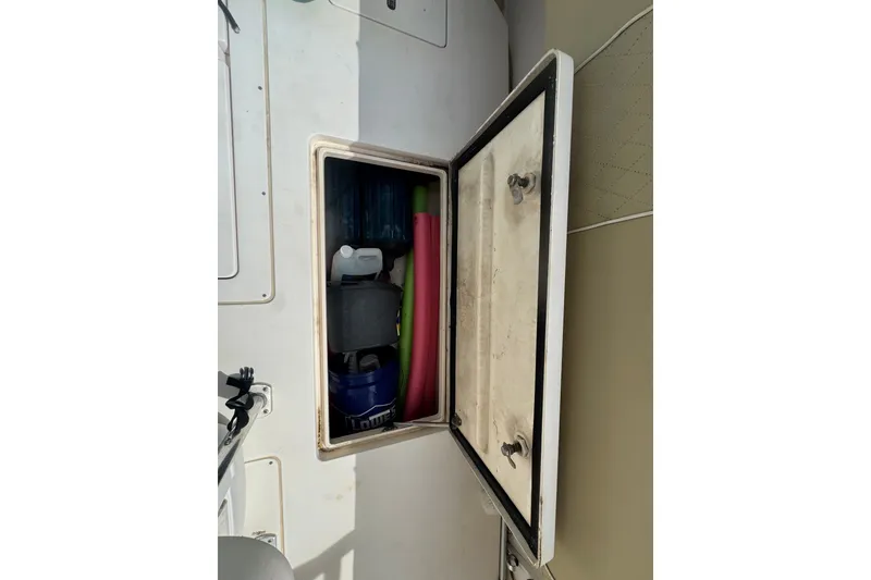 Slide: The Image of Storage compartment on a 2008 Intrepid 370 Cuddy boat, containing various items. - 23