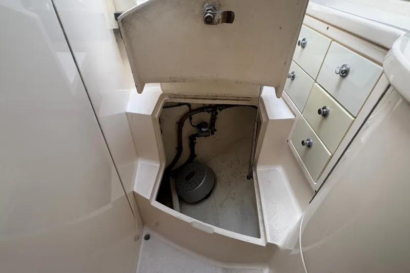 Slide: The Image of 2008 Intrepid 370 Cuddy storage compartment with open hatch and adjacent drawers. - 48