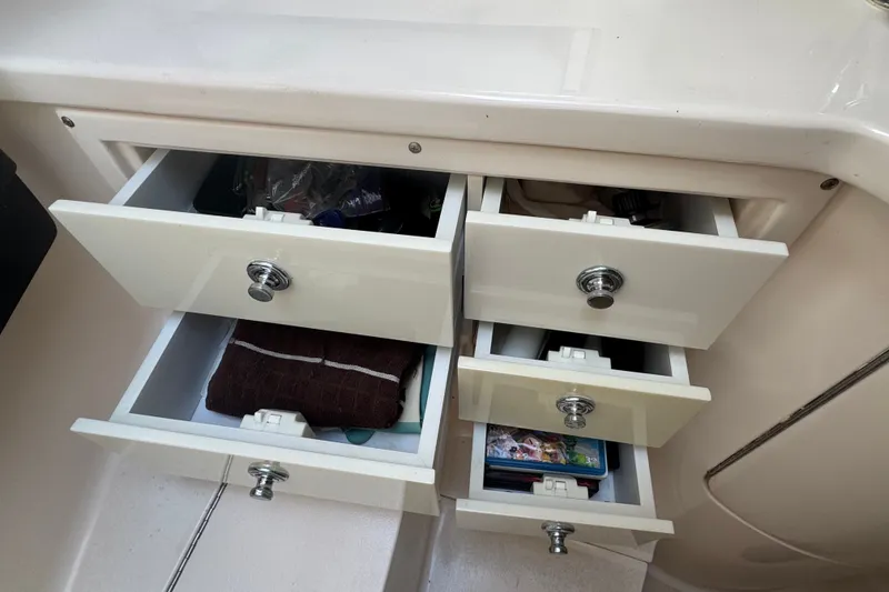 Slide: The Image of Open storage drawers inside a 2008 Intrepid 370 Cuddy boat, showcasing organized compartments. - 51