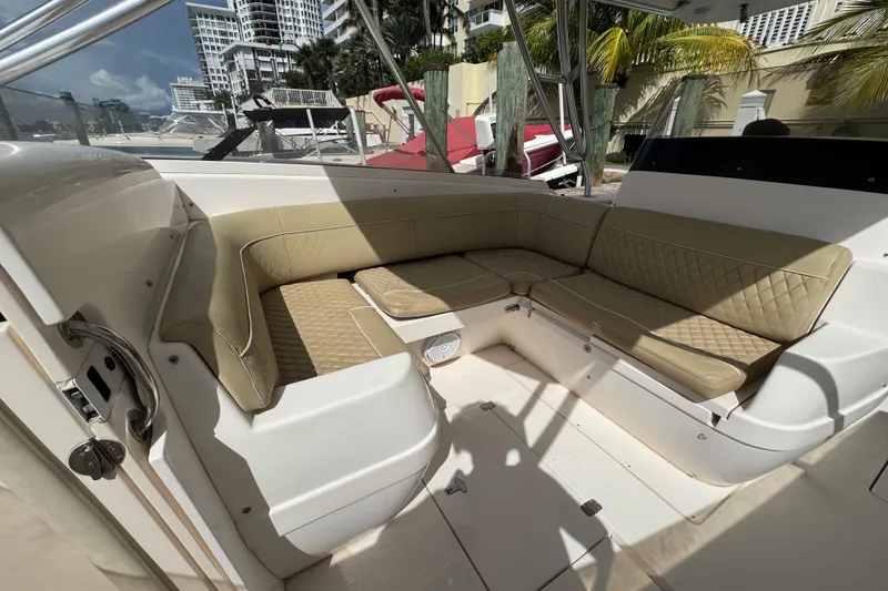Slide: The Image of Interior of a 2008 Intrepid 370 Cuddy boat with beige seating and urban backdrop. - 36